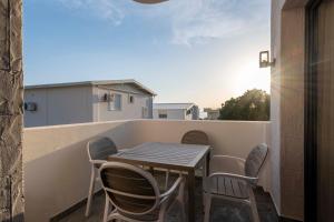 a table and chairs sitting on a balcony with the sunset at ZIS LUX Sea View in Kravlja