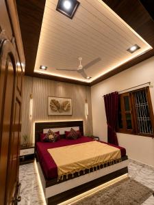 a bedroom with a large bed with red sheets at Lakshman Guest House Ayodhya in Jāmb