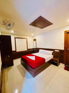 a bedroom with a large bed with a red blanket at Meridian Residency in Ernakulam +9 photos