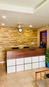 a lobby with a clock on a brick wall at Meridian Residency in Ernakulam