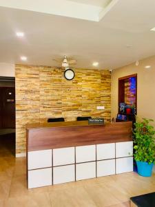 a lobby with a counter with a clock on the wall at Meridian Residency in Ernakulam