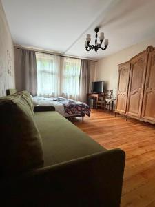 a living room with a couch and a bed at Zacisze Trzech Gór- klimatyczne noclegi i restauracja in Jedlina-Zdrój