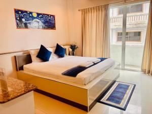 a bedroom with a large bed with blue pillows at Ree- Riverside hotel in Bangkok
