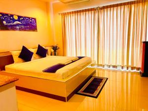 a bedroom with a large bed in front of a window at Ree- Riverside hotel in Bangkok