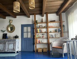 a room with a book shelf and a blue door at Jégmadár Festőporta in Somogyfajsz