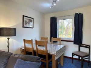 a living room with a table and chairs and a couch at Corrie View in Roybridge
