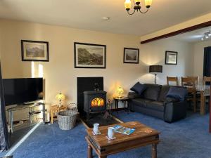 a living room with a couch and a fire place at Corrie View in Roybridge