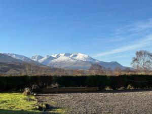 a snow covered mountain in the distance with a road at Corrie View in Roybridge +8 photos