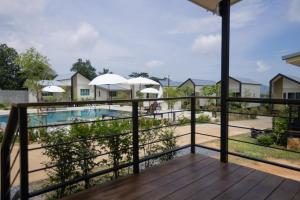 a balcony with a view of a pool and houses at NaraRin Phuket Resorts in Thalang