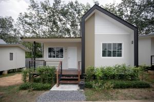 a small white house with a black roof at NaraRin Phuket Resorts in Thalang +11 photos
