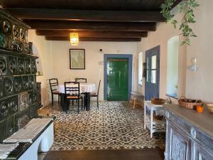 a living room with a table and a green door at Jégmadár Festőporta in Somogyfajsz