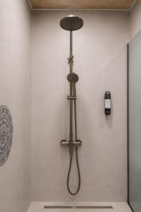 a shower in a bathroom with a shower head at Комплекс Шампион in Kazanlŭk +28 photos