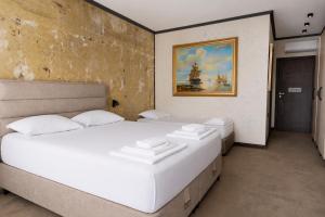 a bedroom with two beds and a painting on the wall at Комплекс Шампион in Kazanlŭk