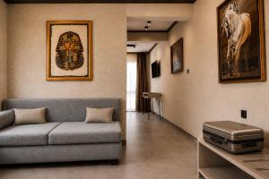 a living room with a couch and a horse picture on the wall at Комплекс Шампион in Kazanlŭk