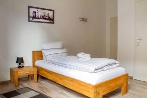 a bed with white sheets on it in a room at Gästehaus Elisabeth in Schlangenbad