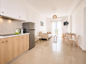 a kitchen and a living room with a table at Eleftheria Hotel & Apartments in Ornos