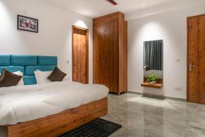 a bedroom with a large bed with a blue headboard at The Royals Luxury Apartments Rooftop Restaurant Lift Live Music Sat in Kasauli