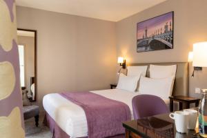 a hotel room with a bed and a desk at Hôtel Le Relais Saint Charles in Paris