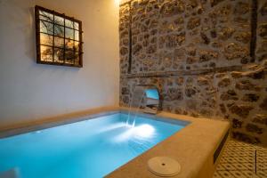 a swimming pool in a room with a stone wall at Casa de Mamachon in Cazorla