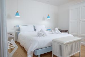 a white bedroom with two beds and a stool at Villa Rose Sardegna in Calasetta +37 photos