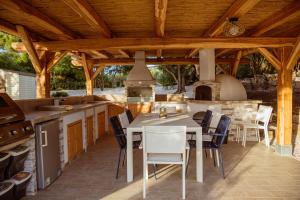 an outdoor kitchen and dining area with a table and chairs at Villa Rose Sardegna in Calasetta