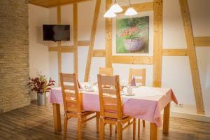 a dining room with a table with chairs and a tv at Gästehaus Elisabeth in Schlangenbad