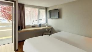 a hotel room with a bed and a window at Campanile NATURE - Marne La Vallée - Chelles in Chelles +27 photos