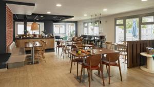 a restaurant with tables and chairs in a room at Campanile NATURE - Marne La Vallée - Chelles in Chelles