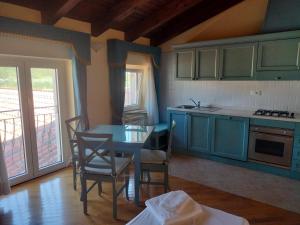 a kitchen with blue cabinets and a table and chairs at Agriturismo Hermada in Duino
