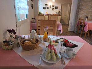 a table with a plate of food on a pink table cloth at Gästehaus Elisabeth in Schlangenbad