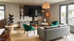 a living room with a couch and a tv at Campanile NATURE - Marne La Vallée - Chelles in Chelles