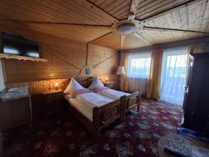 a bedroom with a bed in a wooden room at Pension Hubertushöhe in Kulmbach