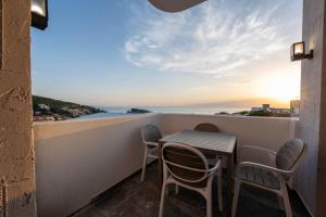 a table and chairs on a balcony with a view of the ocean at ZIS LUX Sea View in Kravlja