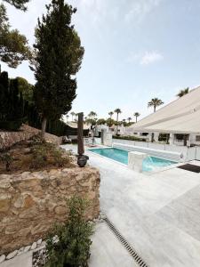 a swimming pool with a stone wall next to a building at Villa Capitan in Orihuela Costa