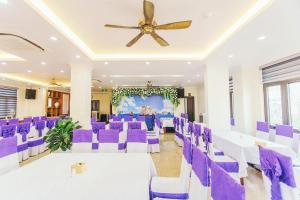 a room with purple chairs and a ceiling fan at White Crown Hotel Ha Long in Ha Long