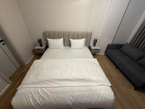 a bed and a couch in a small room at Struga Lake Suites in Struga +30 photos