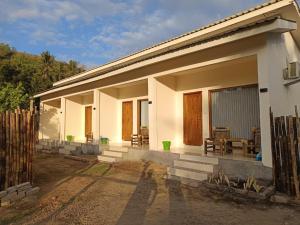 a white house with a fence in front of it at AWAN Homestay in Kuta Lombok