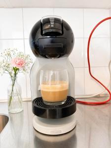 a coffee maker sitting on a counter with a cup of coffee at M & M home in Karlshamn