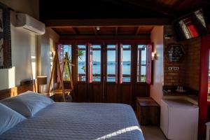 a bedroom with a bed and a view of the ocean at Pousada Mar de Dentro in Florianópolis +88 photos