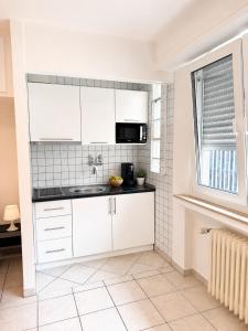 a kitchen with white cabinets and a microwave at Private Urban Studio 18 - Luxembourg Central in Luxembourg