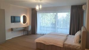 a bedroom with a bed and a tv and a window at Struga Lake Suites in Struga
