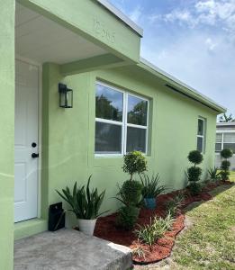 a green house with plants in front of it at cozy bohemian in North Miami