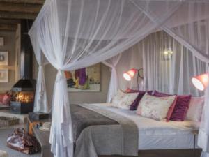 a bedroom with a bed with a canopy at Onguma The Fort in Namutoni Gate +11 photos