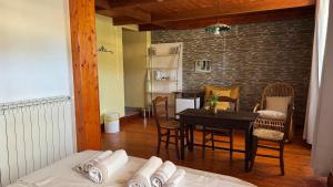 a room with a table and chairs and a kitchen at B&B Muggianeddu in Tonara