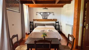 a bedroom with a bed with a table and chairs at B&B Muggianeddu in Tonara
