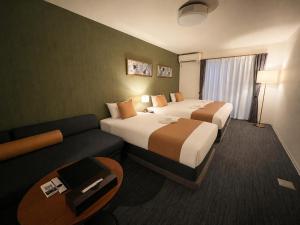 a hotel room with two beds and a couch at &zen Kyoto Gion in Kyoto