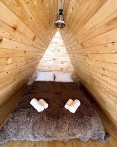 a bed in a wooden room with two pillows at Larda in Nankvam-Zagrali