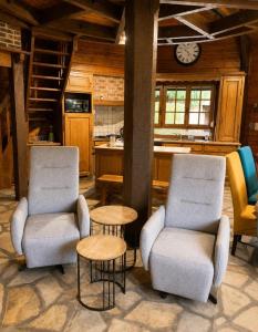 two chairs and a table in a kitchen with a clock at Le coin de paradis in Bouvellemont