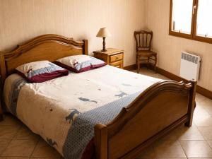 a bedroom with a large bed and a chair at Le coin de paradis in Bouvellemont