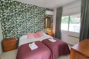 a bedroom with a bed with two towels on it at Opening Doors Premiá Dalt Amazing views w pool in Premia de Dalt +71 photos